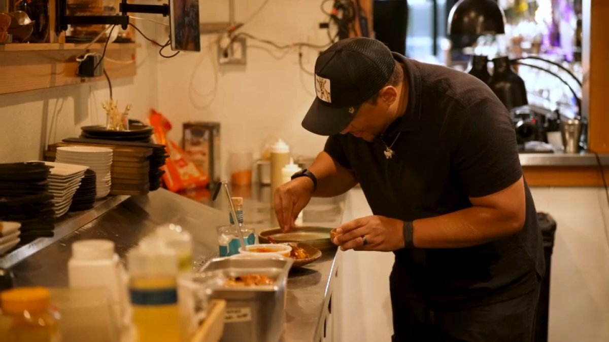 Chef Nelson German plating food in a restaurant kitchen